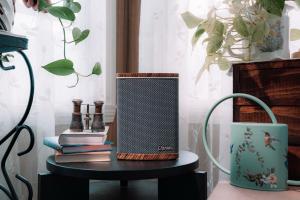 The Cherish Home Hub on a side table next to a stack of books