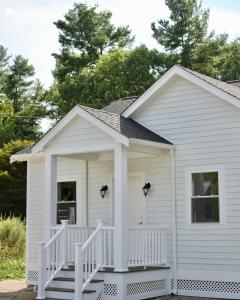 A white single floor 500SF ADU with 3 steps and a covered landing