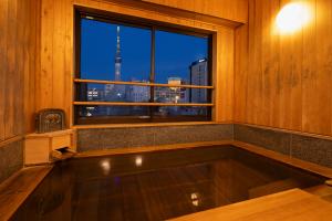 The sixth-floor observation bath at Ryokan Asakusa Shigetsu, overlooking Tokyo Skytree
