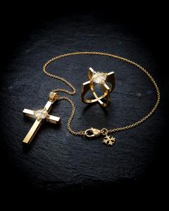 VERGEZ™ The Covenant fine jewelry duo featuring the Amorae gold ring and Domorae Cross of Return pendant with matching gold chain, displayed on dark stone.