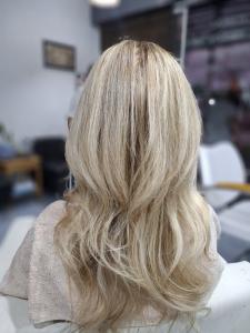 Long blonde hair with highlights in soft waves, seen from behind, at Hair & Beauty Salon in Chiang Mai