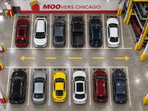 Overhead view of vehicles parked in marked bays beneath MOOvers Chicago branding