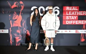 RLSD 2026 Overall Winner Tal Zohar stands beside a model wearing her tennis-inspired design, featuring a white quilted leather jacket, pleated leather skirt and visor, against the Real Leather. Stay Different. event backdrop.