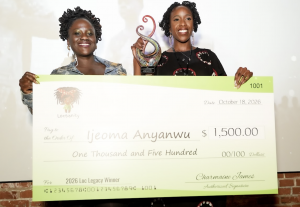 LOCnificent founder Lovaeta Amoako and Loc Legacy Award winner Ijeoma Anyanwu smile while holding an oversized $1,500 Locsanity check and a glass trophy at LOCnificent 2026.