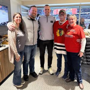 Jeff Nydegger standing with four guests in a hockey arena suite during the 2025 Military Appreciation Night celebration.