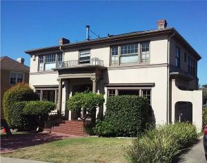 Exterior of a two-story Oakland home featuring newly installed seamless rain gutters and downspouts along the roof perimeter.