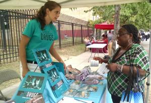 Thalia Ghiglia, DFW DC Coordinator, sharing drug prevention materials at a table event..