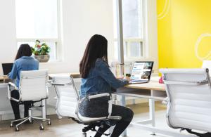 A woman reviews the 2020 Future of Work Report: What the Future Holds for Coworking and Remote Work on a computer.