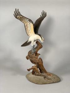 Hand-carved and painted figure of an Osprey hawk by artist Wendell Gilley (Maine, 1904-1983), depicting the Osprey in flight landing on a driftwood branch, artist signed (est. $250-$450).