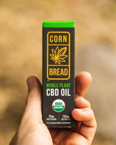 A customers holds a package of Cornbread Hemp's USDA certified organic Whole Flower CBD Oil.