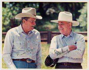 Original color photograph of Ronald Reagan and Russian leader Mikhail Gorbachev, showing the two men wearing Western hats in an outdoor setting, signed by both (est. $3,500-$4,000).