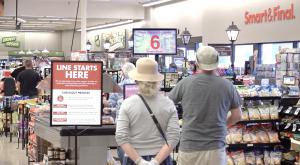 A couple waiting in a single-line queue at Smart & Final