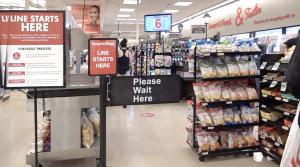 A sign notifies customers of where the single-line queue begins inside a Smart & Final store