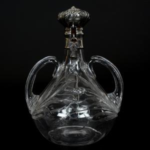 Finely engraved ABCG liquor decanter, 9 ½ inches tall, in a wheat pattern with matching embossed sterling flip lid with wheat motif and a heart-shaped locket. The sterling is marked Theodore B. Starr.