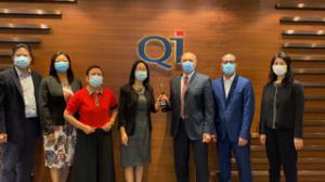 QI group representatives in suits and masks accept award from hr asia representatives