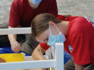 Young woman building a piece of furniture for a new young adult library at the Quigley House