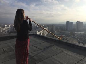 Alphorn player Anna Katharina Schumann rehearses for "Sky above Prohlis" on some of the highest roofs in Dresden.