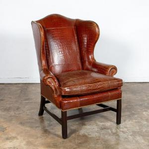Late 20th century genuine alligator upholstered wingback chair by Ralph Lauren with brass nailhead details and a loose cushion, rising on square legs ($22,320).