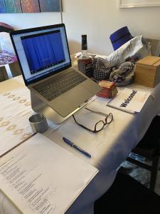 desk area, computer on stand, with props and signs for live show on table