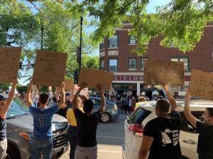 Racial justice protestors holding signs on a street