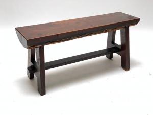 Early 20th century Roycroft Ali Baba bench featuring a plank seat retaining bark to the underside and presented on a trestle-style base joined by a mortise and tenon jointed stretcher ($17,220).