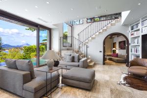 Natural stone tile floors, arched doorways, and wood ceiling beams add artful touches to the contemporary Spanish interior.