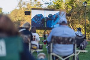 An audience at the Chagrin Documentary Film Festival watches films in the park.