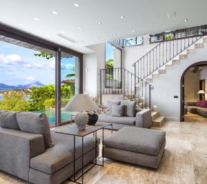 Natural stone tile floors, arched doorways, and wood ceiling beams add artful touches to the contemporary Spanish interior.
