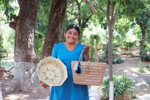 A woman holds up two locally made products.