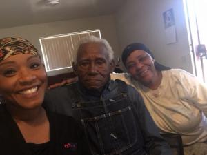 Gray-haired, black WWII Veteran at home with his two daughters by his side