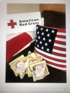 KN95 masks in packaging surrounded by the American Red Cross logo and pillow of the American flag.