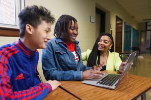 Two teens and an educator use a laptop to access the Money Path app