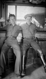 Photograph by Lora Webb Nichols of "Winters and McCarthy", two Civilian Conservation Corps Workers at Sugar Bowl Soda Foundation, Encampment, Wyoming, 1933, two men on barstools with arms around each other's shoulders