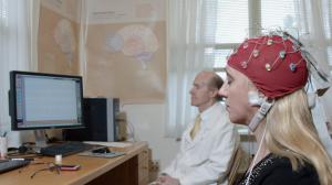 Photo showing a laboratory experiment in brain-wave measurement with the subject being a meditating woman