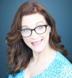 red haired white woman with blue dress with polkadots with arms like she is running and face looks suprised with mouth open a little bit