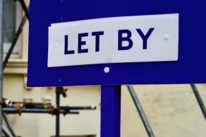 Blue sign with bold lettering reading 'LET BY' on it