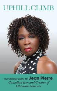 Image is the book cover for the memoir, Uphill Climb. It features a photo of Jamaican-Canadian Celebrity Skincare Entrepreneur, Jean Pierre, in a black and white top and the cover has green borders and lettering.