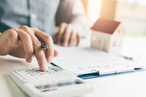 Home agents are using a calculator to calculate the loan period each month for the customer