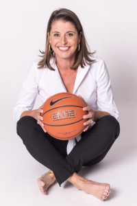 Image of Joanne P. McCallie sitting on floor holding basketball