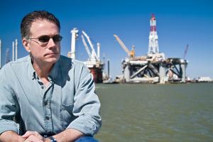 Man sat in front of oil rig