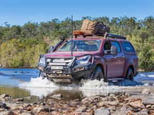 Offroad vehicle splashing through muddy creek