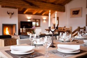 The highest floor of Chalet Maurine boasts a spectacular open living and dining area with a fully equipped kitchen, dining area and living area with a natural stone fireplace perfect to curl up next to after a long day on the slopes.