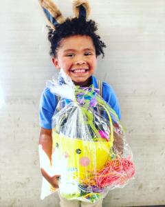 Excited kid with Easter basket from Project Boon's free Easter event in 2020