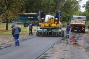 Workers Place Romix RoadSafe Asphalt Mix on Wet Road in Rainy Conditions, Senekal, South Africa.