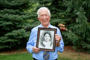 Holocaust survivor Joe Rubinstein holding photo of his beloved mother  that he had not seen since he was taken from the Radom, Poland, Ghetto in 1941