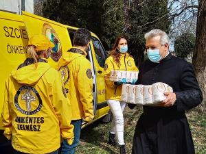 Catholic priest helps unload supplies donated by the Scientology Volunteer Ministers for needy families in his diocese.