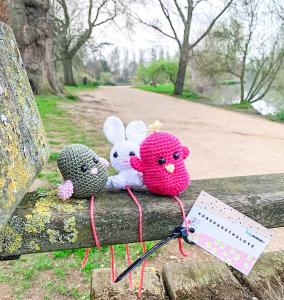 Three handmade knitted animals on a riverside bench in Oxford