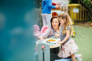 Photo of Parenting Coach and influencer 2021 Harriet Crouch founder of Mini Explorers Consultancy playing in a garden with a small girl