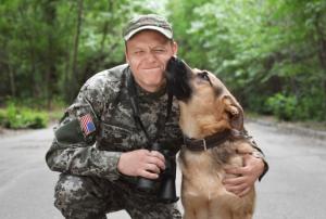 Photo: Man in military uniform with German shepherd dog, outdoors | Credit: Shutterstock Royalty-free stock photo ID: 1114507862