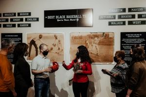 Visitors are shown baseball artifacts from 1900 era Black players at the Louisville Slugger Museum and Factory